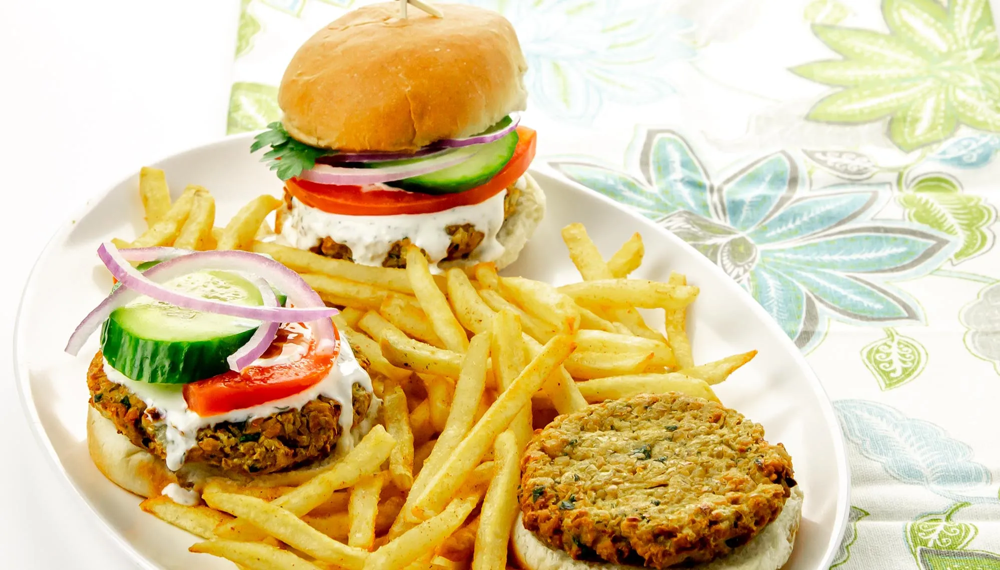 3 sliders with falafel patties on a platter with fries