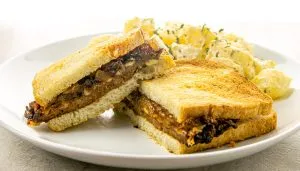 patty melt with caramelized onions and potato salad on the side