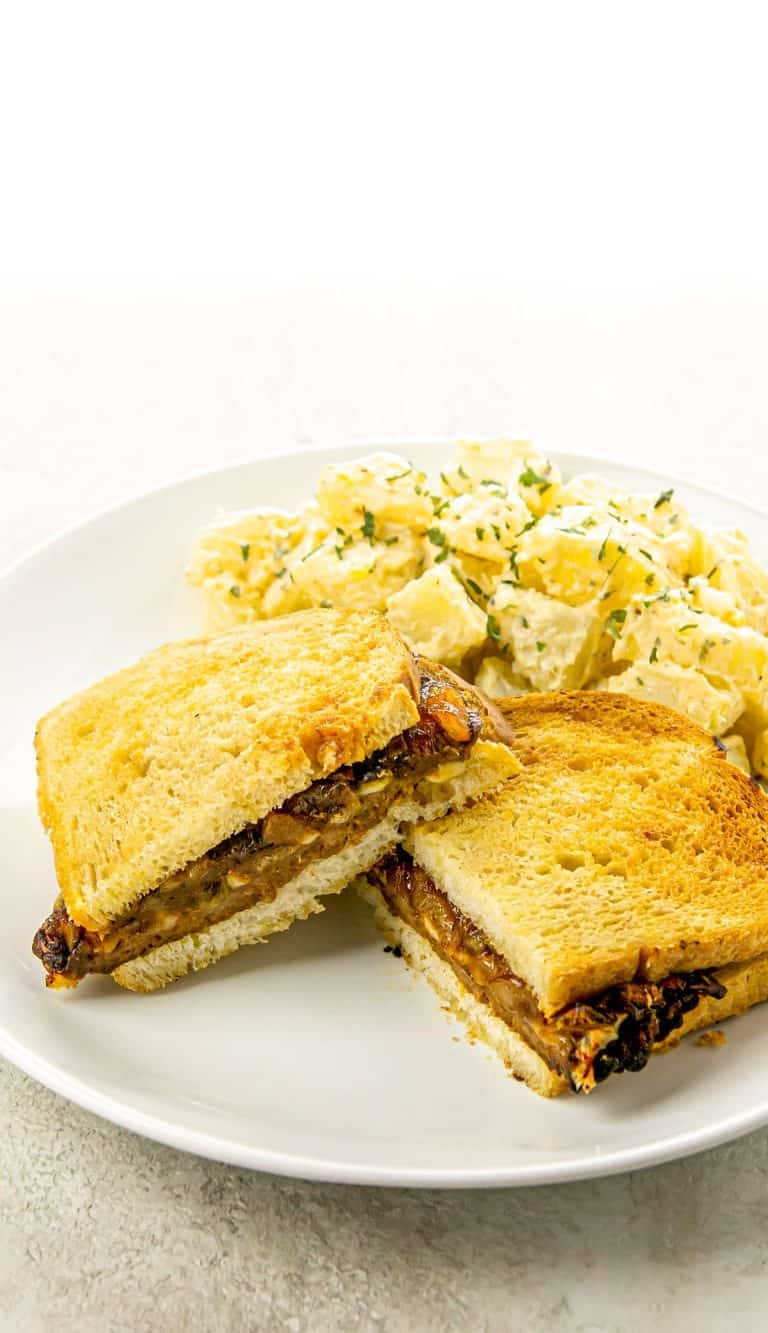 patty melt with caramelized onions and potato salad on the side