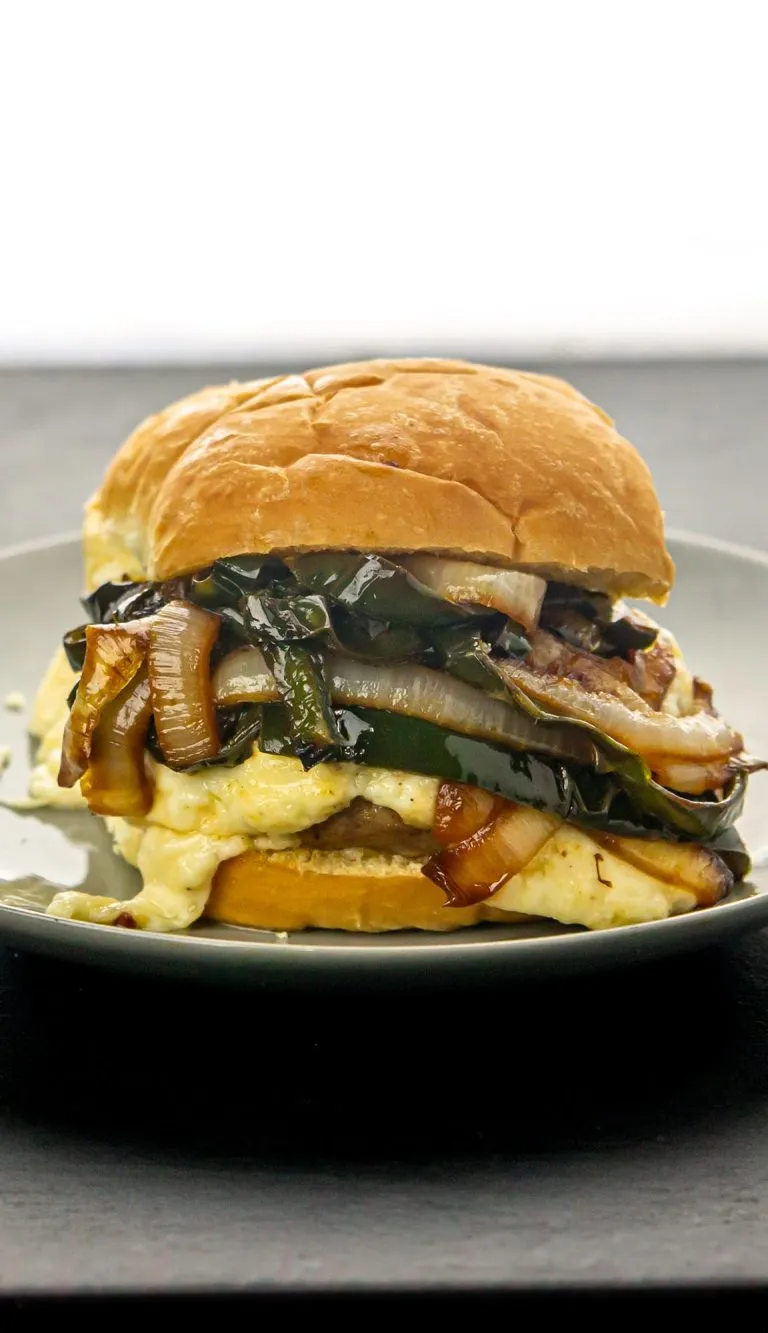 Pepper jack topped pork burger smothered in caramelized onions and poblano peppers