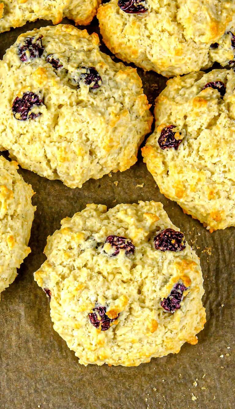 Baked scones with dried cherries on brown parchment paper.