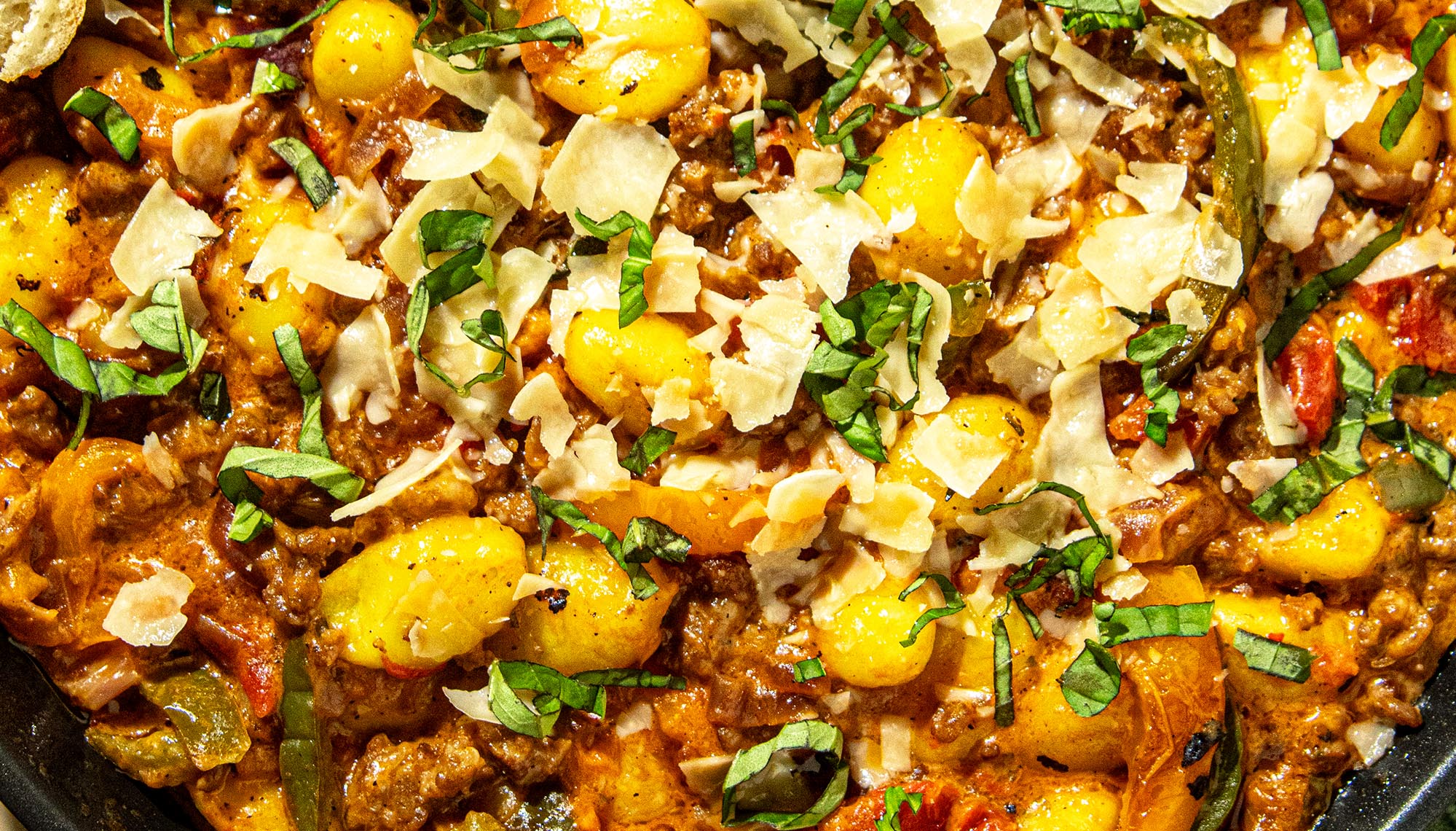 Gnocchi baked with ground meat, tomato sauce, topped with shaved cheese and chopped fresh basil.